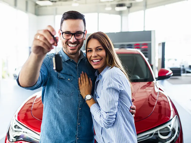 couple holding new car key