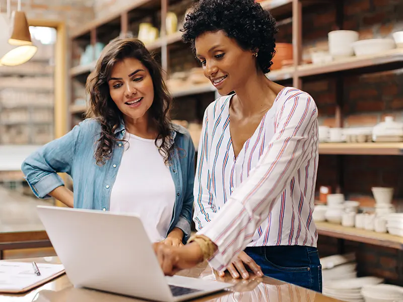 two woman looking at laptop